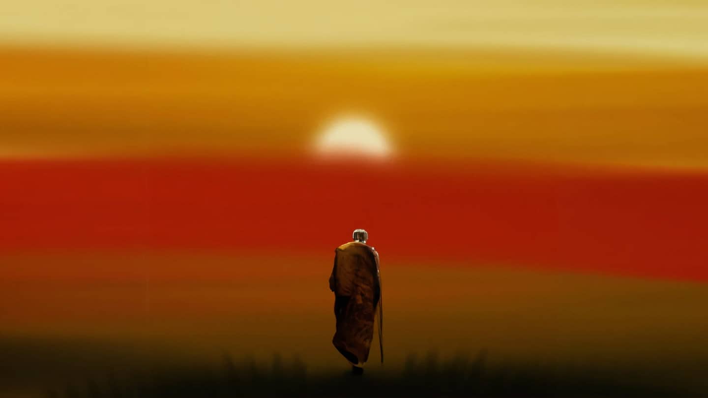 A Buddhist monk walking towards the setting sun